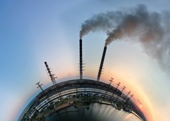 Aerial view from high altitude of little planet earth with coal power plant high pipes with black smokestack polluting atmosphere. Electricity production with fossil fuel concept.
