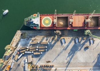 Top view from a drone of a large ship loading grain for export. Water transport